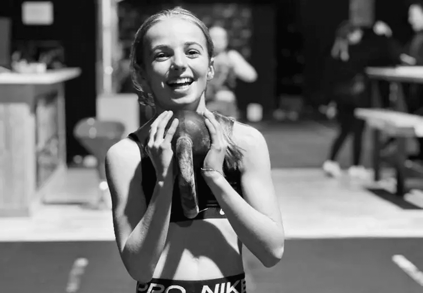 Jeune athlète à la box souriante, kettlebell en main — cours kids